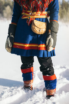 Anonymous person in kofte and mittens with Saami bag