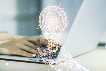 Double exposure of creative light bulb hologram with hands typing on laptop on background, research and development concept