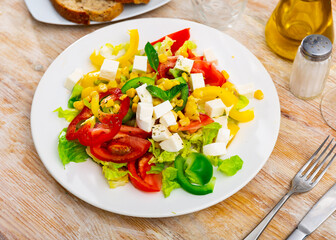 Delicious light vegetable salad of tomatoes, canned corn, pepper and Feta cheese