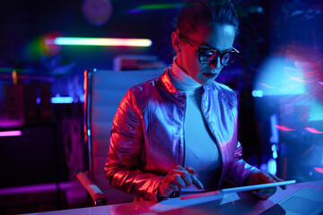 Fototapeta na wymiar elegant woman in glasses using tablet PC in modern office