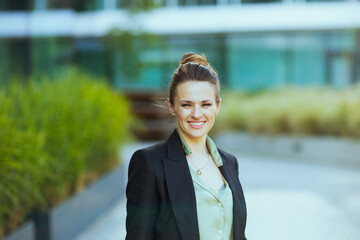 Portrait of happy modern female employee in business district