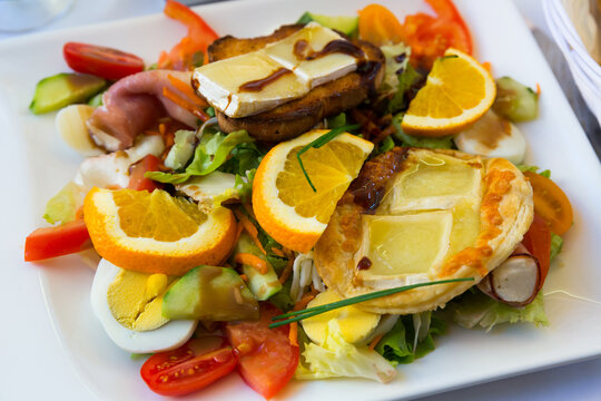Salad from goat cheese with honey and orrange at plate, dish of french cuisine