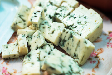 A soft cheese diced on a plate for picnic snacks or canapes This is the Camembert or Brie, family of cheeses