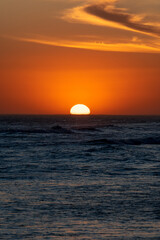 Sun setting in the sea with beautiful cloud arrangement. Concepts of calm and vacation.