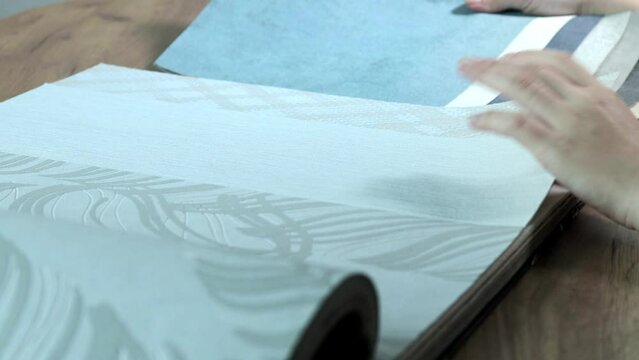 Professional dectorator choosing fabric swatches, she is touching the samples with her hands. Home design and renovation concept.