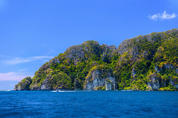 Naklejka na ściany i meble Speed boats in the bay of Ko Phi Phi Don Island with huge rocks and cliffs on a sunny day, Ao Nang, Mueang Krabi District, Krabi, Andaman Sea, Thailand