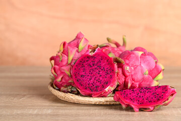 Red dragon fruit or pitaya in basket on wooden background, Tropical fruit in summer season