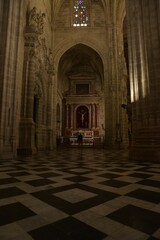 Geometrically tiled floor leading to Crucifijo chapel with José de Arce altarpiece under Renaissance decorated vault and sparkling glass window at Iglesia San Miguel church in Jerez, Spain