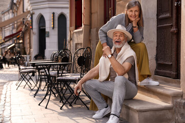 Smiling affectionate senior couple outdoors, space for text
