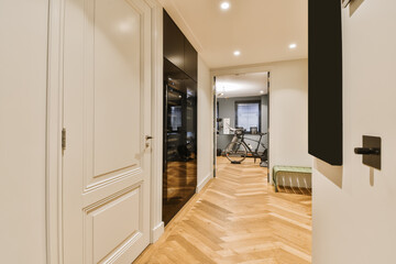a hallway in an apartment with hardwood flooring and white trim on the walls, there is a bike...
