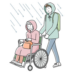 雨の中を避難する車椅子に乗った高齢女性と支援する男性