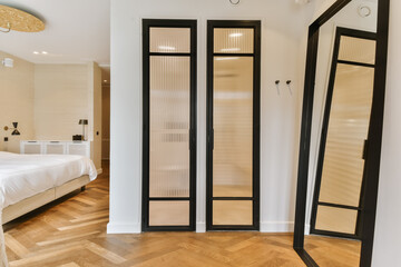 a hotel room with a bed, mirror and two mirrors on the wall in it's corner to the left