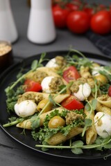 Delicious pesto pasta salad on gray table, closeup
