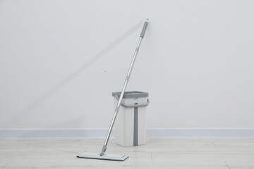Mop and plastic bucket indoors. Cleaning floor