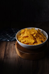 Corn Chips. Chips in white bowl on natural wooden table. in dark and texture background. good for snack time