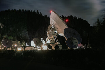 vue sur une antenne satellite ronde blanche la nuit avec des lumières rouges aux extrémités