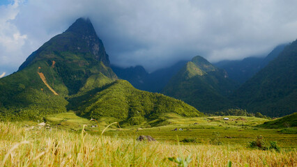 Beautiful landscape mountain green field grass meadow white cloud blue sky on sunny day. Majestic green scenery big mountain hill cloudscape valley panorama view in countryside greenery pasture