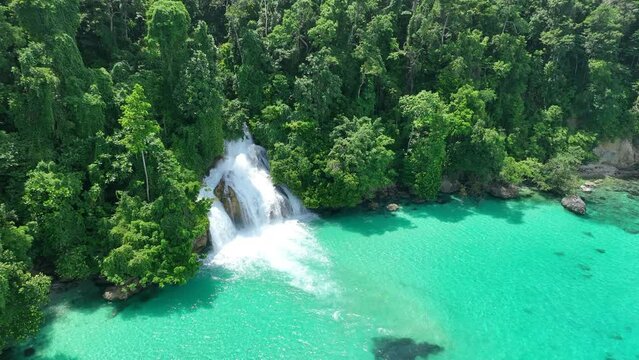 The scenic Momon waterfall tumbles from the primordial rainforest of West Papua into the shallow sea. This spectacular waterfall is found about a day's sail north of Kaimana.  