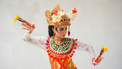 girl wearing Balinese traditional dress with a dancing gesture on white background with hand-held...