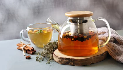 Fototapeten Winter herbs and spices tea in glass teapot and mug, alternative medicine for the immune system, herbal hot drink concept © Uuganbayar