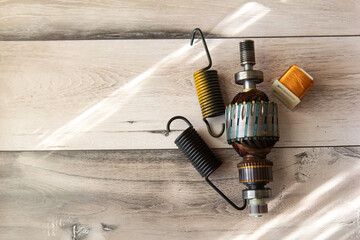 Close up view of electric motor rotor and metal spins on wooden background. Copy space