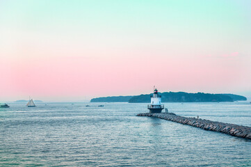 Sunset on Spring Point lighthouse in Portland Maine. Windjammers, favorite tourist attraction in Maine.