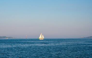 Ocean with sailboat in the background. Blue ocean and white Sailboat 