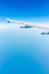 View from the airplane window at a beautiful cloudy sky and the airplane wing