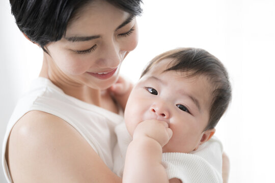 Lovely Asian (Japanese) mother holding her baby Close-up looking at the camera