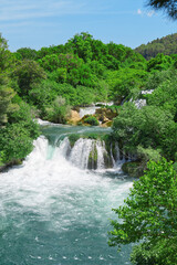 Fototapeta premium Beautiful Waterfall background in sunny summer day. Beautiful Waterfall In Krka National Park - Croatia, Europe. Krka river waterfalls in the Krka National Park