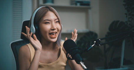 Cheerful Young podcaster use microphone during online podcast in studio