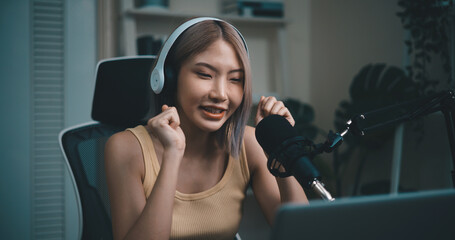 Cheerful Young podcaster use microphone during online podcast in studio