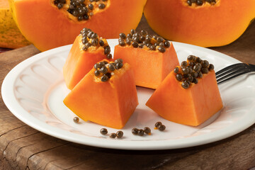 Ripe pieces of papaya on plate. Selective focus.