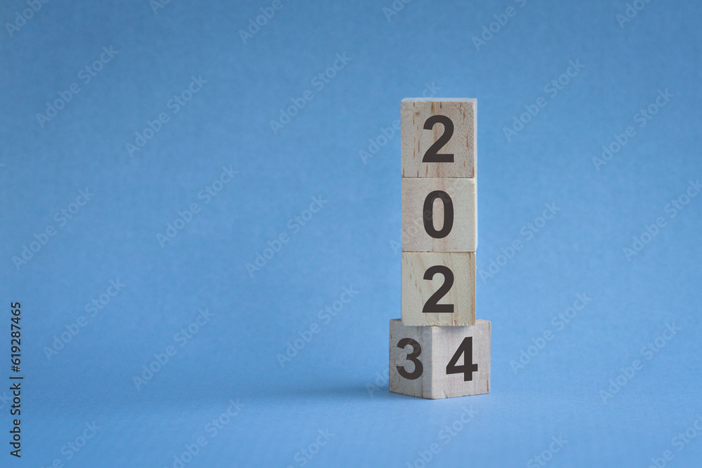 Wall mural wood cubes or blocks stack on table, turn of year from 2023 to 2024. on blue background.