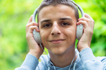 Portrait of a teenager with headphones outdoors,teenager listens to music