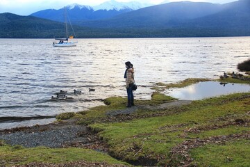 Fototapeta na wymiar Tourist playing and enjoying beautiful Te Anau lake.
