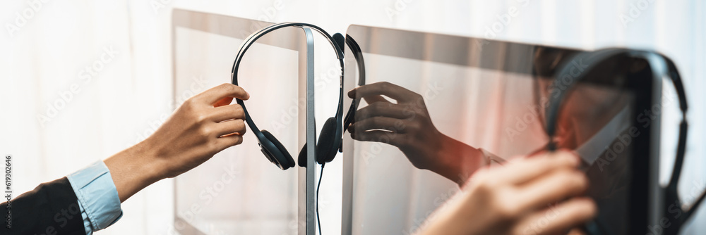 Aufkleber panorama focus hand holding headset on call center workspace desk with blur background of operator t