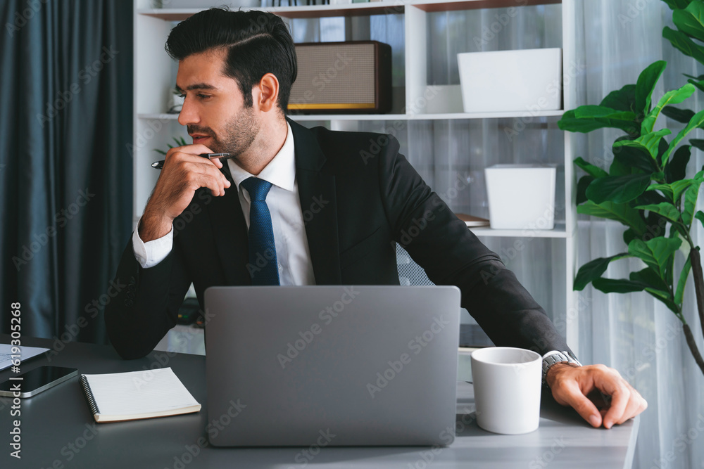 Poster modern professional businessman at modern office desk using laptop to work and write notes. diligent