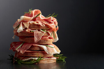 Italian prosciutto or Spanish jamon with bread and rosemary.