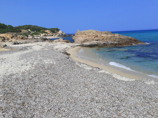 Castiadas, Italy - june 30, 2023: Punta di Santa Giusta beach, Costa Rei, in the province of the South Sardinia. A lot of soft sand between the rocks, an intense blue sea with very few bathers