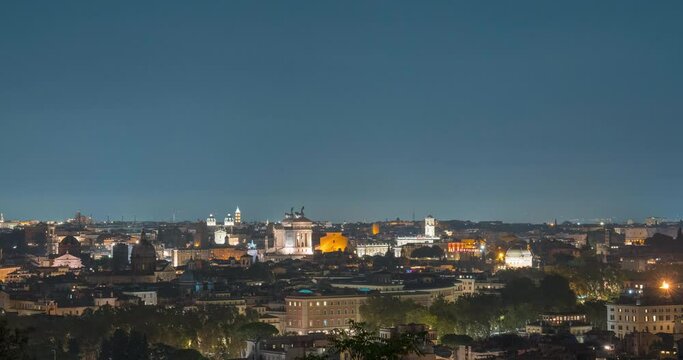 4K Panoramic rooftop view of the beautiful cityscape of Rome with mountains beyound the city and clouds in night sky in time-lapse. Roma from above, from the hill of Terrazza del Pincio. Italy.