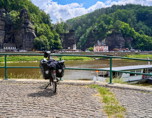 Bike with panniers on a platform with a view across the Elbe to the Czech village of Hrensko, Czech...