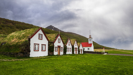 Fototapeta na wymiar Traditional turf farm in Laufas, iceland with barn and church in summer