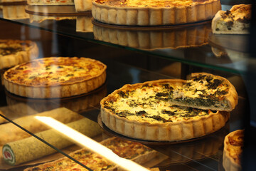 Fototapeta premium Different delicious quiches on counter in bakery shop, closeup