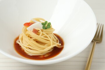 Tasty spaghetti with sauce served on white wooden table, closeup. Exquisite presentation of pasta dish