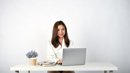 Asian businesswoman working on her tasks on her laptop at her desk. isolated white background