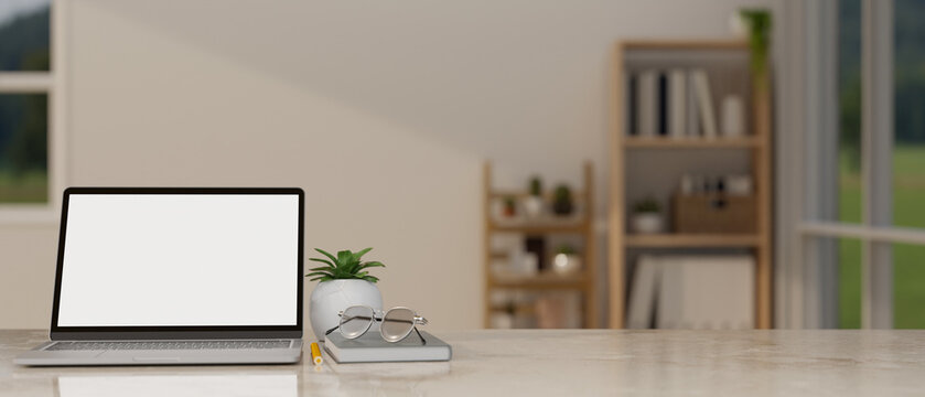 A laptop mockup on a tabletop in a minimal cozy living room. workspace close-up image.