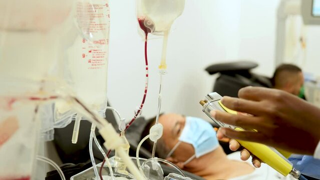 Nurse checking on the Dialysis machine while patients wait