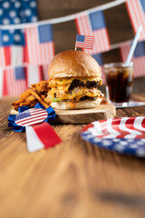 Fourth of July celebration. American flag and decorations. Burgers on rustic wooden table.