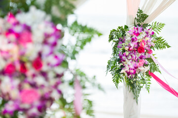 Floral arrangement at a wedding ceremony on beach.